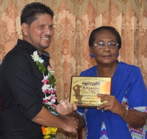 Ramnaresh Sarwan receives a plaque from his former Headmistress at Stella Maris Primary, Natalie Arthur