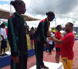 Jadyn George was the lone female to win a gold medal for Guyana. Here she receives her medal from Suriname's coach, Gordon Touw Ngie Tjouw