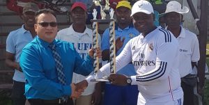 The Buxton captain receives the winner's trophy from ECCB president, Bissoondyal Singh